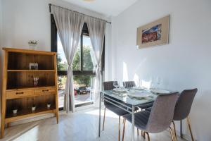 comedor con mesa, sillas y ventana en Apartamento Mairena en Mairena del Aljarafe