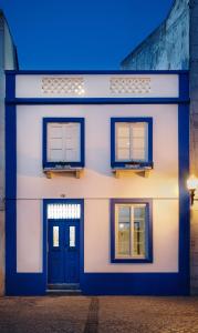 une maison blanche avec deux fenêtres et une porte dans l'établissement Casa Calmaria Beja, à Beja