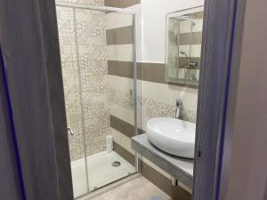 a bathroom with a sink and a glass shower at Hotel Poker in Naples