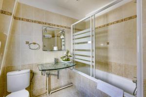 a bathroom with a toilet and a sink and a tub at Hôtel du Square d'Anvers in Paris