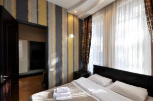 a bedroom with a bed and a tv and a window at Hotel Majestic in Tbilisi City