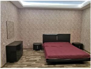 1 dormitorio con 1 cama roja y 2 altavoces en 3-bedroom apartment Most City area en Dnipro