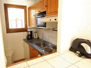 a small kitchen with a sink and a microwave at Appartement 3 pièces 6 couchages LA SALLE LES ALPES - FR-1-330F-26 in Serre Chevalier