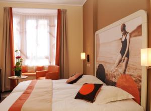 ル・テュケ・パリ・プラージュにあるレッド フォックスのホテルルーム ベッド1台、壁に大きな絵が描かれたベッド1台付