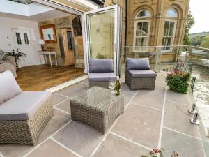 a patio with wicker chairs and a table at Belvedere Farm in Halifax