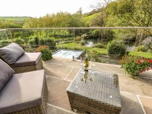 a patio with a couch and a table with a bottle of wine at Belvedere Farm in Halifax