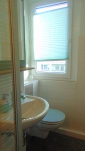 a bathroom with a sink and a toilet and a window at Ferienwohnung August 18 in Gelenau