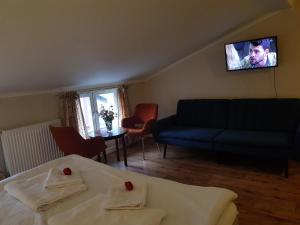 - un salon avec un canapé et une télévision murale dans l'établissement Appelberg hotel, à Sollefteå