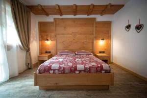 una camera con un grande letto con testiera in legno di Agriturismo Dalla Natura la Salute a Giustino