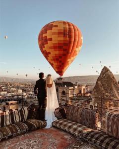 una novia y un novio de pie en la parte superior de un globo de aire caliente en Harman Cave Hotel, en Göreme