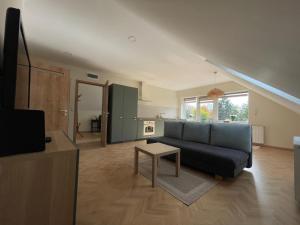 a living room with a blue couch and a table at Koliko apartman in Mohács