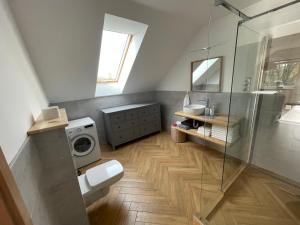 a bathroom with a shower and a washing machine at Koliko apartman in Mohács