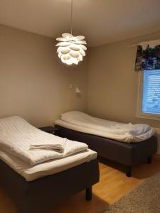 Habitación con 2 camas individuales y lámpara de araña. en Jääskän Loma Ratatie 3 asunto 6 Kauhava en Kauhava