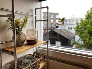 a shelf with a vase and a basket on a window at Broncks Apartment 3 - Modern 1-Bedroom in the Heart of Tórshavn in Tórshavn