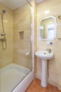 a bathroom with a shower and a sink and a tub and a mirror at Центр. Острозького. Цум. 2 кімнати in Ternopilʼ