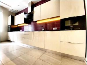 una cocina con armarios blancos y fregadero en 2-bedroom Most City Center area apartment, en Dnipro