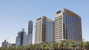 dos edificios altos en una ciudad con palmeras en Movenpick Hotel and Residences Riyadh en Riad