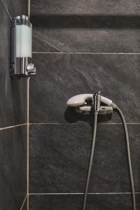 un pommeau de douche fixé à un mur carrelé dans l'établissement Calme en centre ville, appartement 50m de la Place Carnot, à Carcassonne