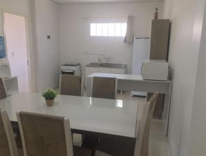 a dining room with a white table and chairs at Pousada Ágata in Ametista do Sul