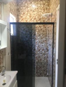 een douche met een glazen deur in de badkamer bij Pousada Ágata in Ametista do Sul