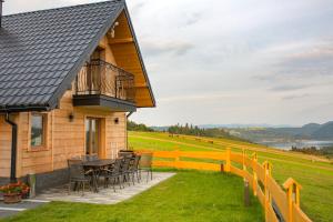 a house with a table and chairs and a fence at Domki Falsztyn in Falsztyn