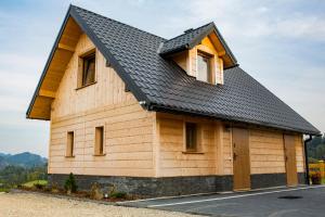 FalsztynにあるDomki Falsztynの黒屋根の木造建築