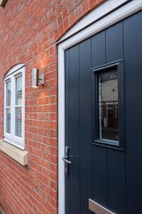 une porte noire sur le côté d'un bâtiment en briques dans l'établissement Sutton House, à Sutton in Ashfield