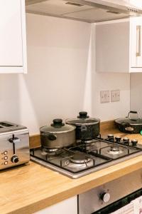 a kitchen with a stove with two pots on it at Sutton House in Sutton in Ashfield