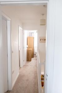 un couloir aux murs blancs et une chambre avec une porte dans l'établissement Sutton House, à Sutton in Ashfield
