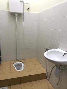 ein Badezimmer mit einem Waschbecken und einem WC auf dem Boden in der Unterkunft Homestay AlFaruqi Gambang (2) in Gambang