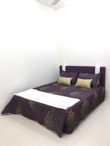 uma cama roxa com almofadas em cima em Homestay AlFaruqi Gambang (2) em Gambang