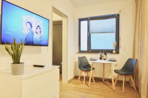 une pièce avec une table, des chaises et un paravent dans l'établissement NEU - gemütliches und modernes Apartment mit Stellplatz, à Coblence