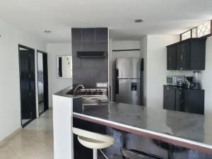 a kitchen with black cabinets and a counter top at ESPECTACULAR APARTAMENTO EN LA PLAYA EL RODADERO in Gaira
