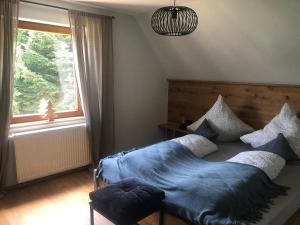 a bedroom with a bed with blue sheets and a window at s´Raubers in Bühlertal