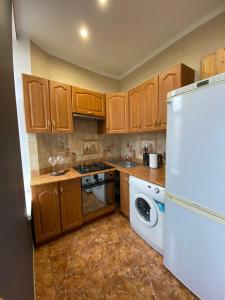 a kitchen with wooden cabinets and a white refrigerator at Quite center of Riga in Riga