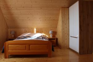 - une chambre avec un lit dans une pièce en bois dans l'établissement Domek Pod Wierzbą, à Sikorzyno
