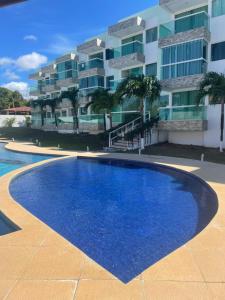 a large blue swimming pool in front of a building at Mar e Sol Residencial em Jacuma PB in Conde