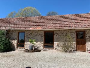 a stone house with two doors and a roof at La Petite Ecurie in Saint-Yrieix-la-Perche