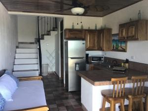 a kitchen with a refrigerator and a counter top at Hotel Los Cielos Del Caribe in Cahuita
