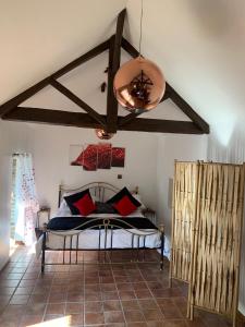 1 dormitorio con 1 cama con almohadas rojas y negras en La Petite Ecurie en Saint-Yrieix-la-Perche