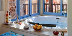 uma banheira sentada num quarto com janelas em Darna bagalil Chardonnay suite Perfect for couples em Lavon