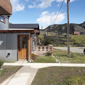 ein Haus auf einer Straße mit einem Berg im Hintergrund in der Unterkunft Cabañas Paso de Viento in El Chalten