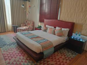 1 dormitorio con 1 cama grande y 1 silla en Hotel Natraj Rishikesh en Rishīkesh