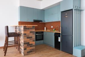 una cucina con armadi blu e un camino in mattoni di Stay Inn-Apartments on Koghbatsi 16 a Yerevan