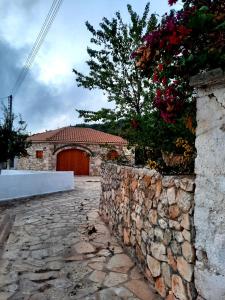 Un muro de piedra delante de un edificio con garaje. en Katoi suite, en Éxo Khóra