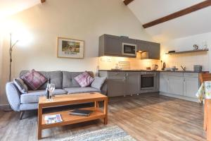 a living room with a couch and a table at Church Farm Holiday Cottages - Pinster Cottage in Ashbourne