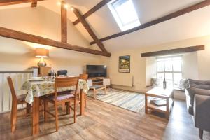 a living room with a table and chairs and a couch at Church Farm Holiday Cottages - Pinster Cottage in Ashbourne