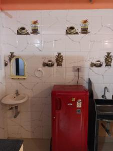 a bathroom with a red refrigerator and a sink at FERNANDES Guest House in Mandrem