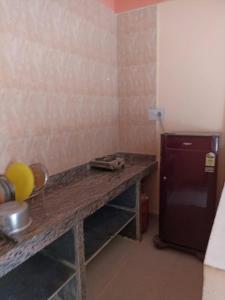 a kitchen with a wooden counter and a small refrigerator at FERNANDES Guest House in Mandrem