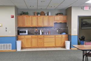 a kitchen with wooden cabinets and a microwave at Heritage Inn in Wahoo